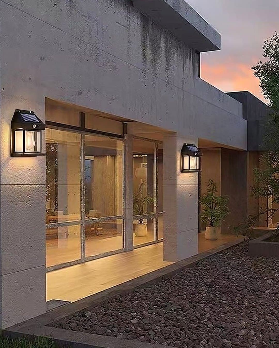 Lampes solaires allumées sur les murs d'une terrasse, en début de soirée